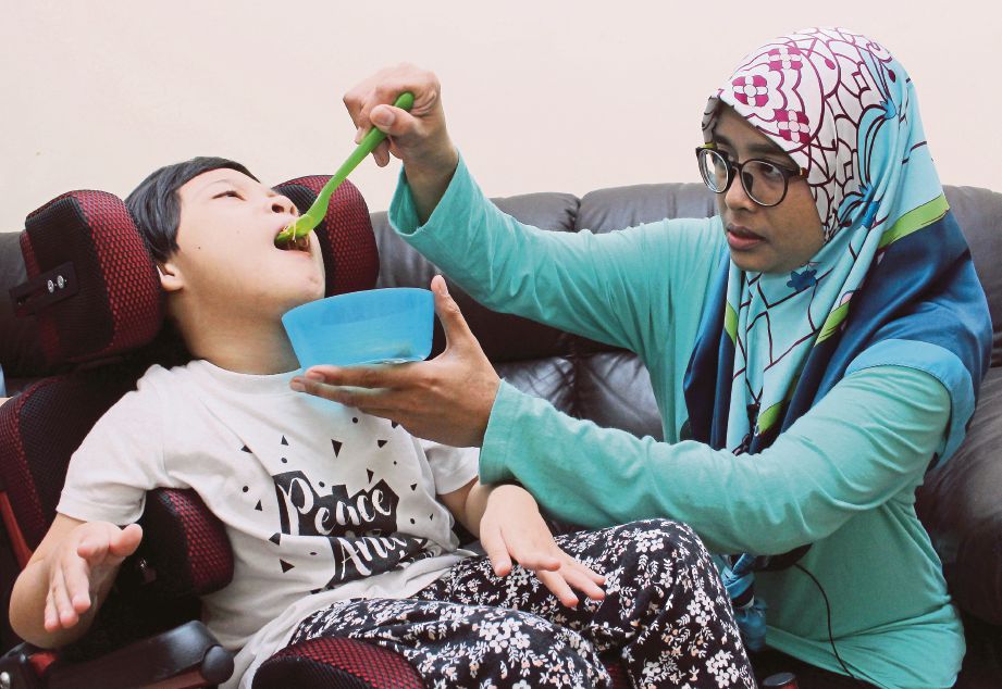 SITI Zailah menyuapkan makanan dan menguruskan Nur Nia Alisha yang menghidap kelumpuhan otak.