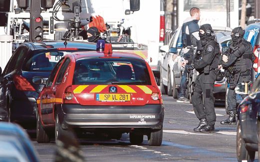 POLIS  memeriksa kawasan selepas seorang lelaki mati ditembak di sebuah balai polis di Paris, semalam.
