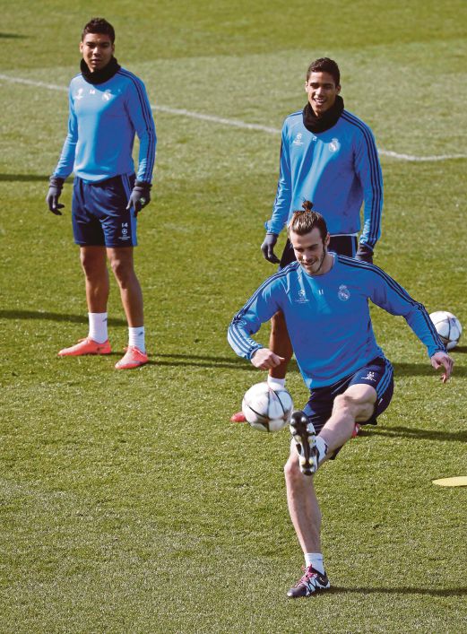 PEMAIN sayap Real  Gareth Bale (bawah) gigih berlatih. 