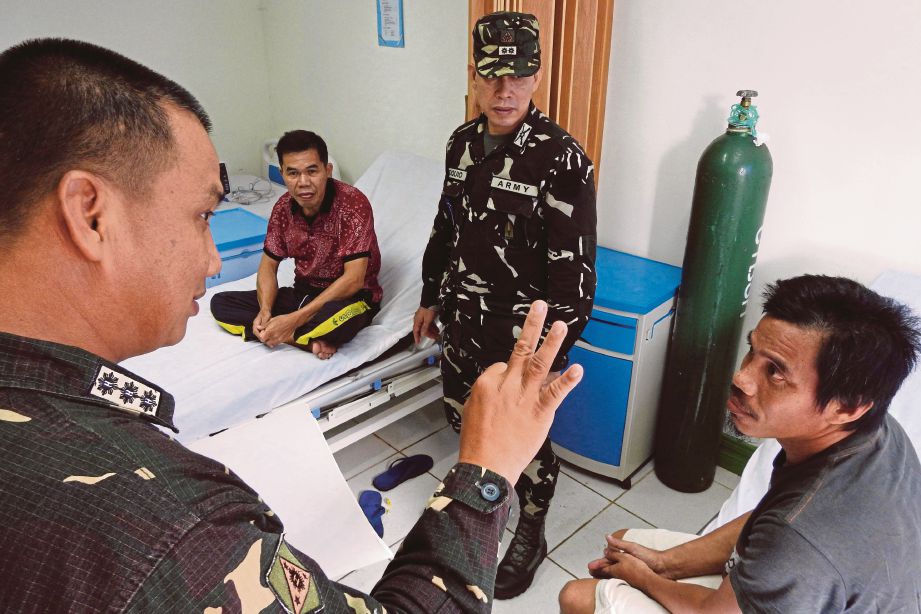 PEGAWAI tentera berbual dengan dua lelaki Indonesia yang dirawat di hospital di Jolo selepas diselamatkan daripada tawanan Abu Sayyaf semalam. - Reuters