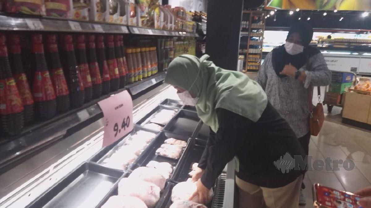 Norazah (kiri) bersama anggota penguatkuasa KPDNHEP Perlis meninjau ayam mentah sejuk beku yang dijual di sebuah pasar raya di Arau dengan harga siling RM9.40 seperti yang ditetapkan kerajaan sebelum ini. FOTO AIZAT SHARIF
