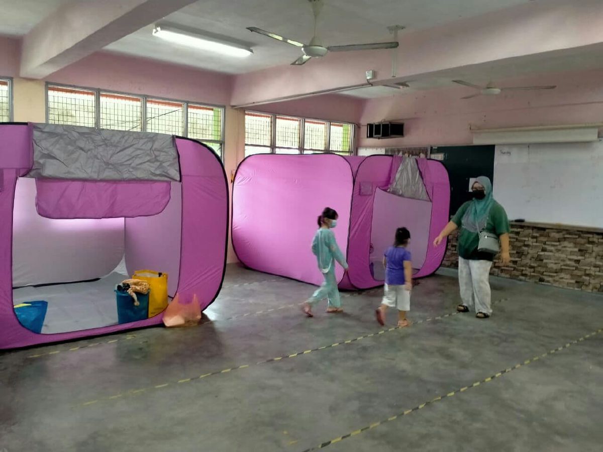 Anggota APM Pontian memasang khemah khas Agensi Pengurusan Bencana Negara (NADMA) di PPS Sekolah Kebangsaan Melayu Raya, Pekan Nenas, yang dibuka mulai jam 11 pagi tadi. FOTO ihsan APM