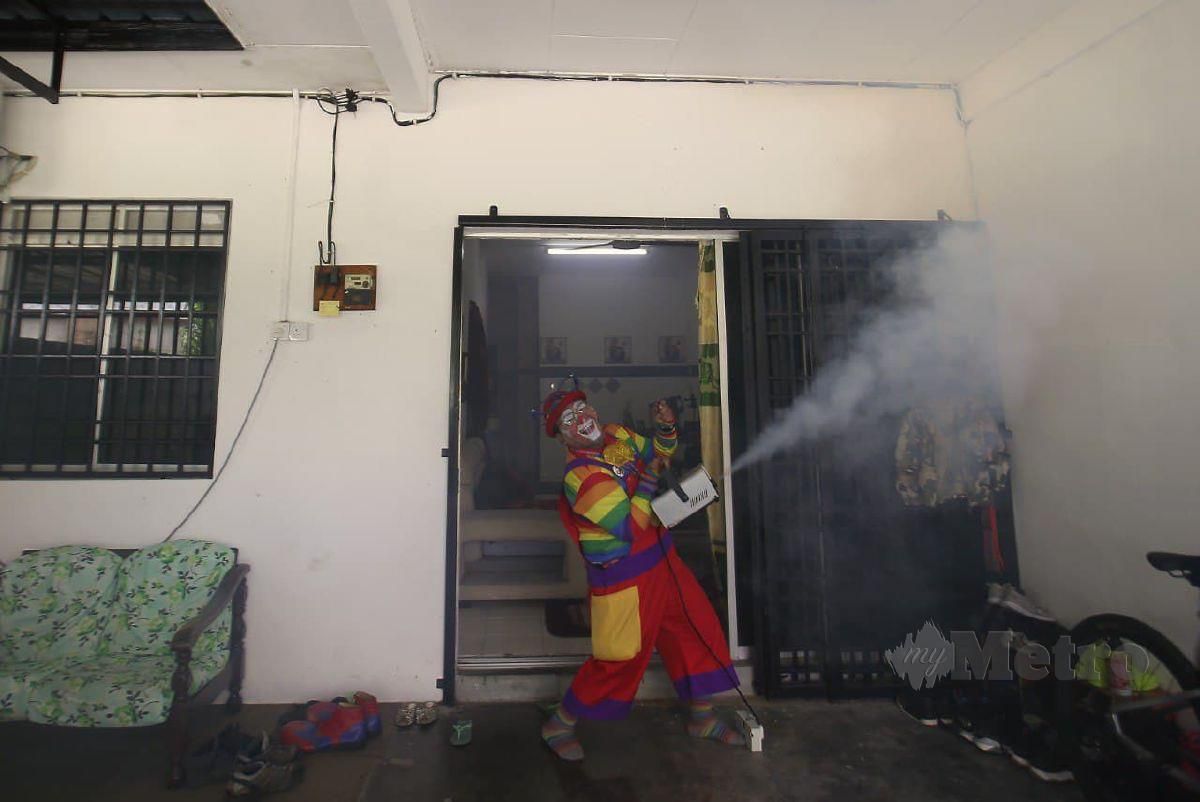 Badut, Shaharul Hisam Baharuddin, 43, (kiri) atau dikenali sebagai 'Piweet De Clown' sedang membasmi kuman sambil menghiburkan kanak-kanak di rumah pelanggannya di Air Kuning. FOTO SHARUL HAFIZ ZAM