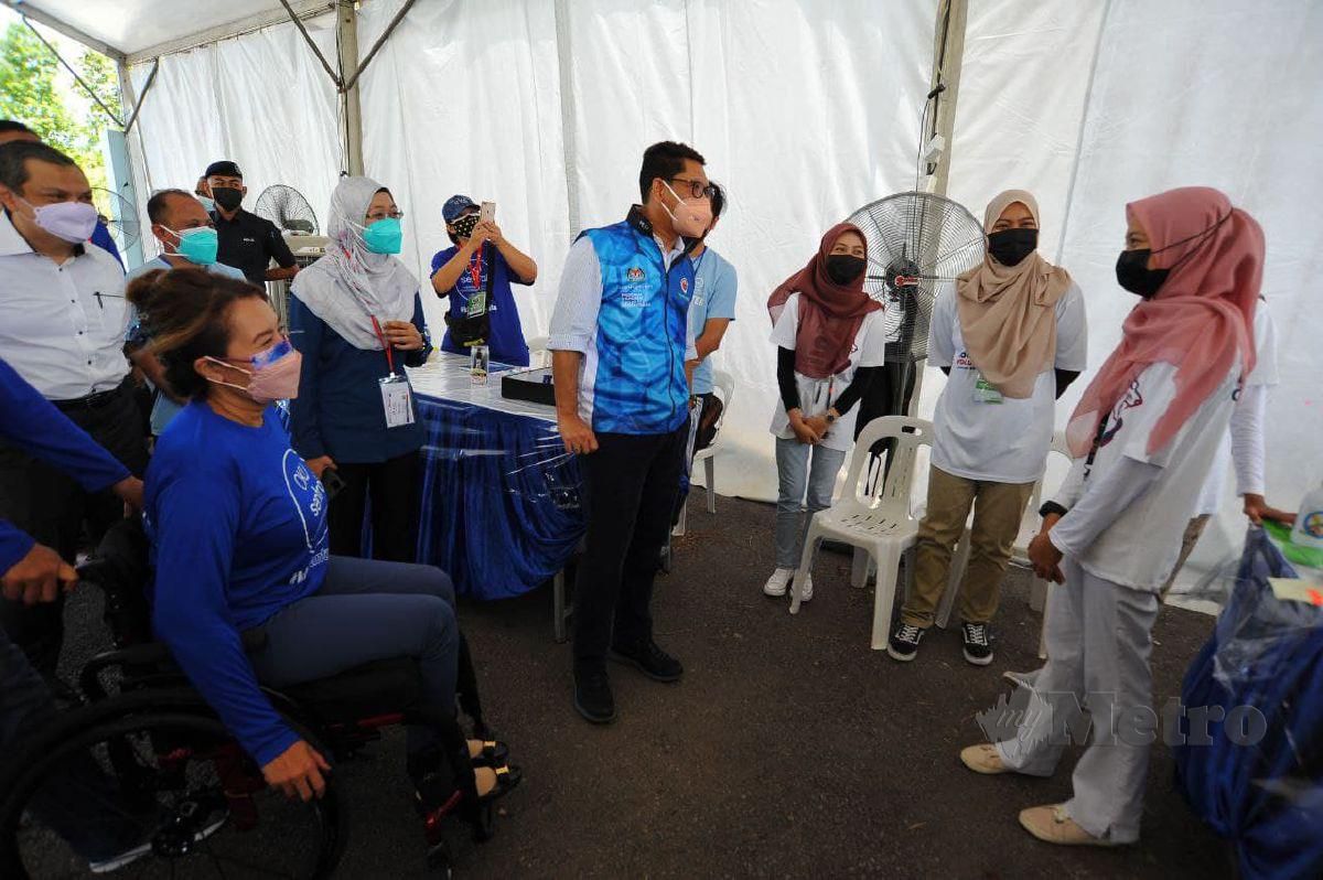 Menteri Belia dan Sukan, Datuk Seri Ahmad Faizal Azumu (tiga dari kiri) mengadakan lawatan di Pusat Pemberian Vaksin (PPV) Pandu Lalu Orang Kurang Upaya (OKU) Sentral di Pusat Akuatik Arena Larkin, Johor Bahru. FOTO NURUL AMANINA SUHAINI