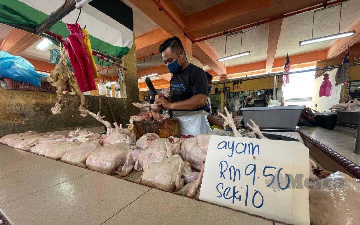 Mohd Anuar Mohd Rashid, 36, Kampung Pasir Panjang sedang memotong ayam di gerainya di Pasar Bukit Besar. FOTO AHMAD RABIUL ZULKIFLI