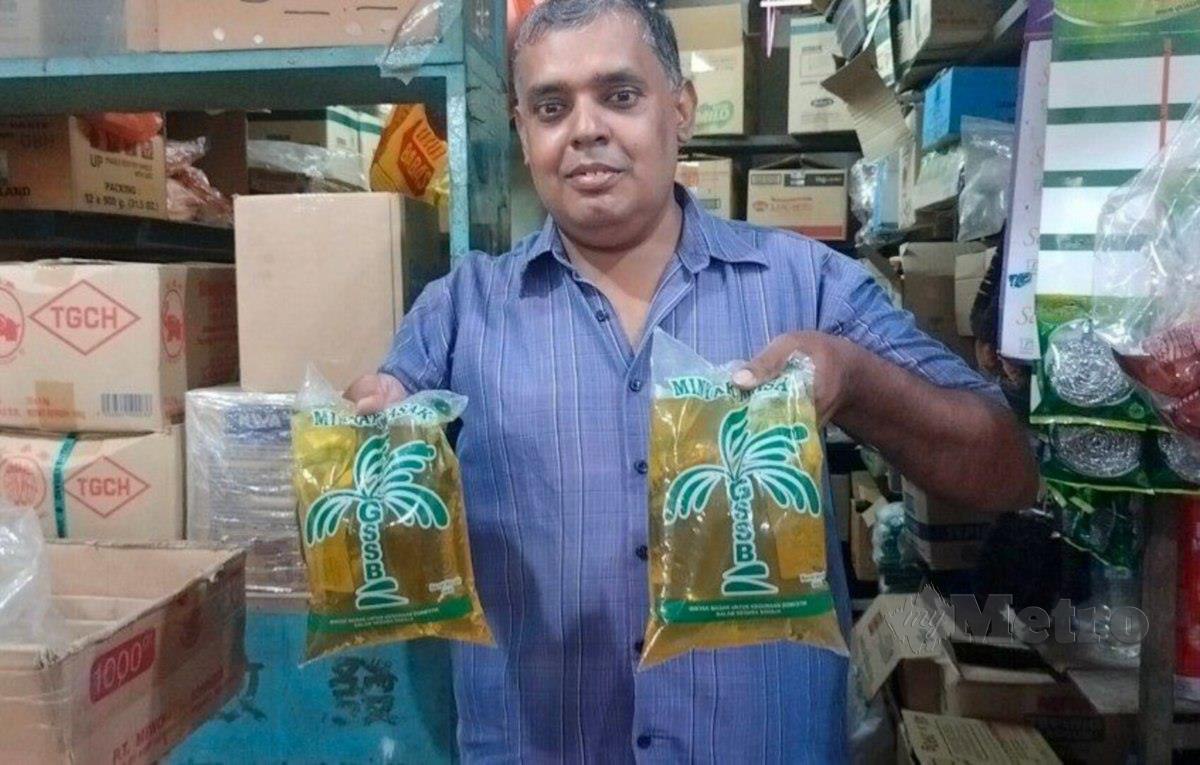 Ajmal Abdul Aziz menunjukkan dua paket minyak masak yang masih ada di kedainya di Pasar Besar Alor Setar. FOTO ZULIATY ZULKIFFLI