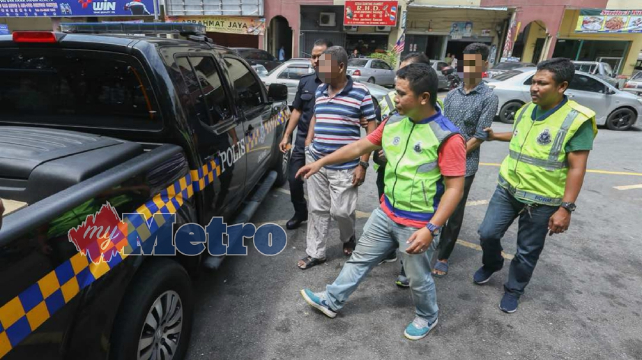 PEGAWAI dan anggota polis menahan dua penjaga kedai minuman keras yang dipercayai menjual arak yang mengandungi bahan Metanol di Jalan Selingsing 4. FOTO Muhd Zaaba Zakeria