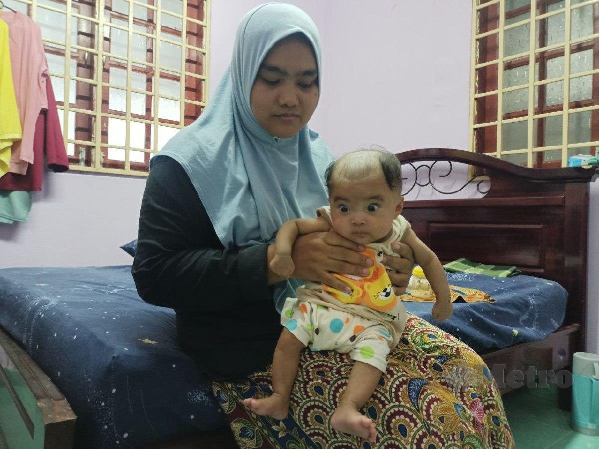 Siti Noraini Mohd Syukri, 36, memangku bayinya, Wan Shahrul Ramadhan Wan Azrizan, lima bulan, yang dilahirkan ketika berusia tujuh bulan dalam kandungan kerana faktor darah tinggi yang naik mendadak. FOTO SITI ROHANA IDRIS