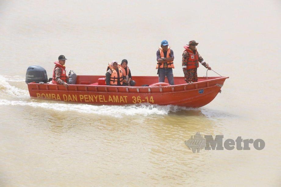 Ibu mangsa Laili Jusoh (dua dari kiri) menaiki bot Bomba dan Penyelamat pada Operasi mencari dan menyelamat (SAR) di Sungai Pahang dekat Kampung Marhum. FOTO MOHD RAFI MAMAT