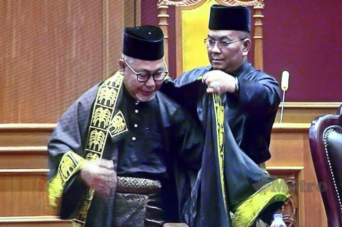Menteri Besar, Datuk Seri Muhammad Sanusi Md Nor  memakai jubah kepada Yang Dipertua PAS Langkawi Zubir Ahmad dilantik menjadi Speaker Dewan Undangan Never (DUN) Kedah yang ke-15 pada Mesyuarat Pertama Penggal Pertama DUN Ke-15 di Wisma Darul Aman di sini, hari ini. FOTO Ihsan Pembaca