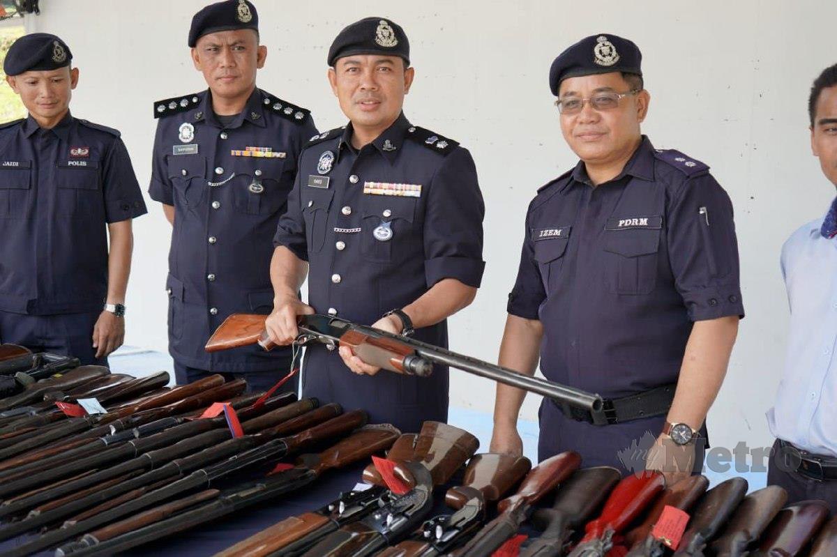 Mohd Haris memeriksa senjata api sebelum dilupuskan di IPD Kudat. FOTO Ihsan PDRM
