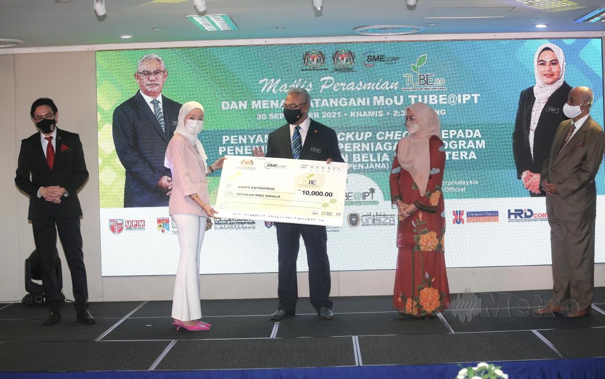 TAN Seri Noh Omar (tiga dari kiri) menyampaikan mockup cheque Geran Perniagaan Program Tunas Usahawan Belia Bumiputera (TUBE@PENJANA) Nor Fatin Suhana Mohd Tajuddin. FOTO Amirudin Sahib
