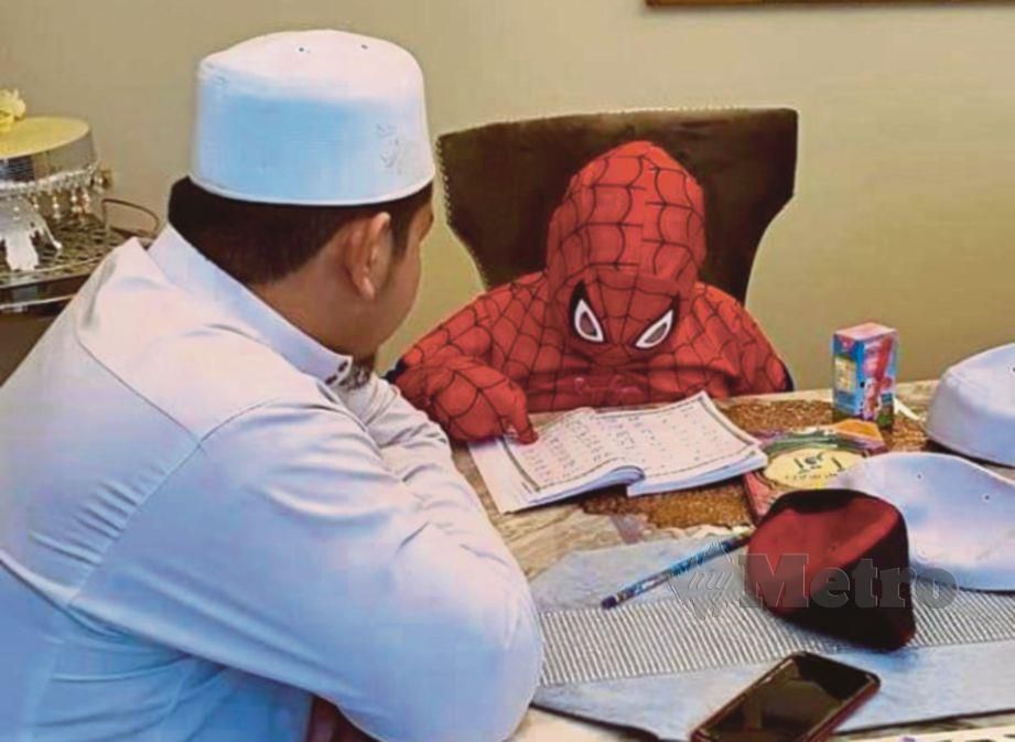 GELAGAT Aiman Khayr yang lengkap berpakaian kostum Spider-Man ketika belajar mengaji. 