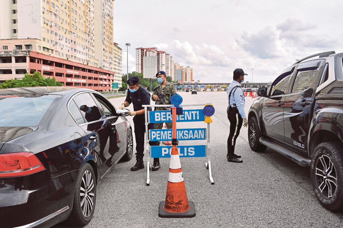 Anggota keselamatan memeriksa kenderaan pengguna jalan raya. FOTO Bernama