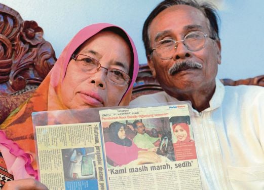 MUKHTAR dan Harison  memegang keratan akhbar berhubung kes pembunuhan  Noor Suzaily pada  2000.