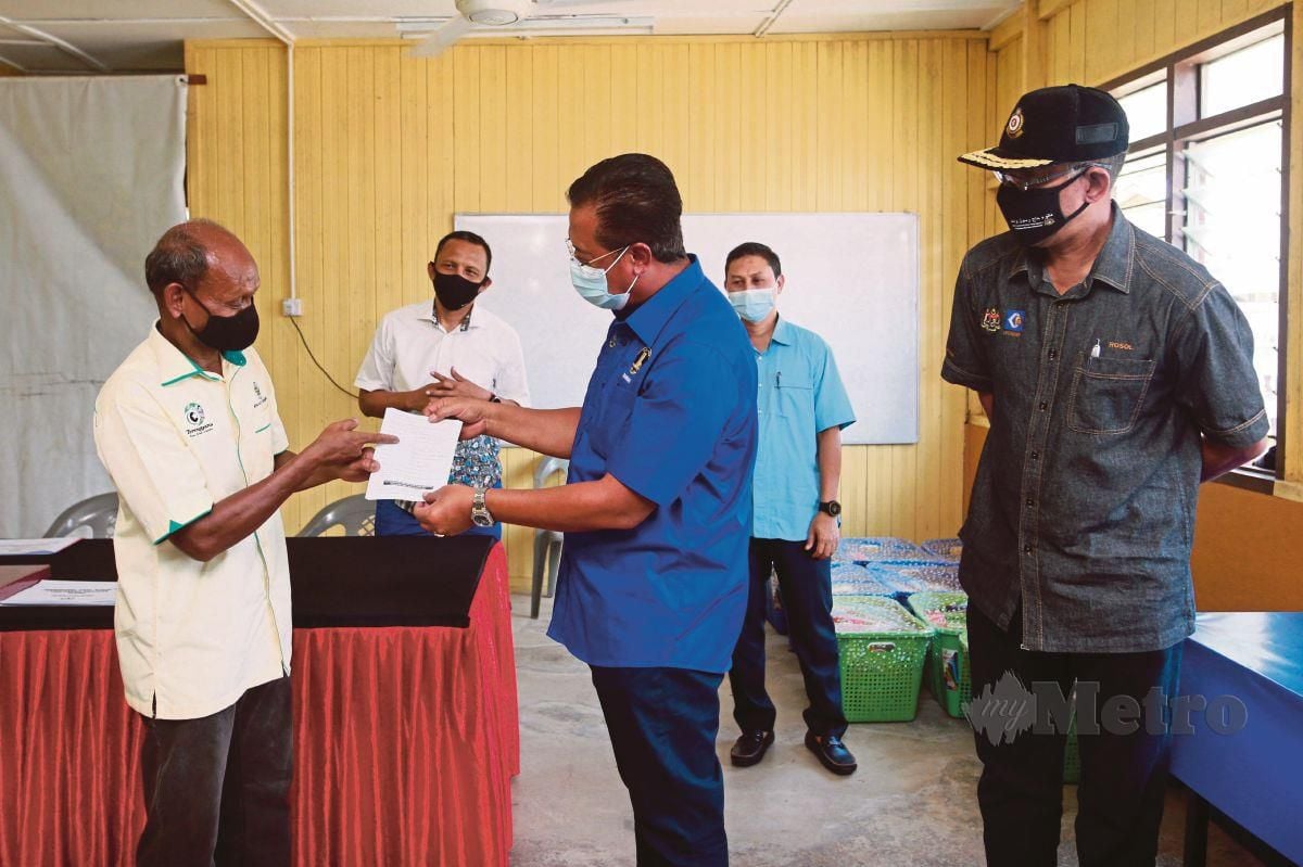 ABDUL Rahman (tengah) diiringi Ahli Parlimen Hulu Terengganu, Datuk Rosol Wahid (kanan) menerima borang pendaftaran suntikan vaksin Covid-19 daripada Pengerusi Jawatankuasa Pembangunan dan Keselamatan Kampung (JPKK) Kampung Sungai Berua, Alias Pelong, 56, (kiri) ketika turun padang menyerahkan bantuan makanan di Perkampungan Orang Asli Sungai Berua.