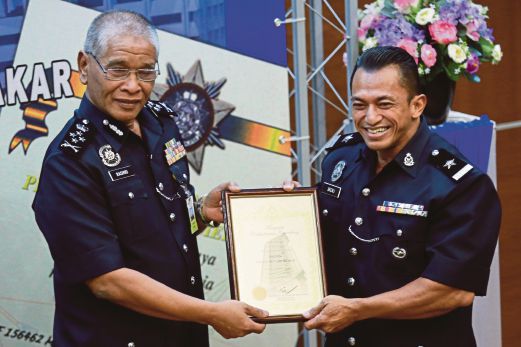 NOOR Rashid (kiri) menyampaikan anugerah kepada Sub Inspektor Sazali Samad. 