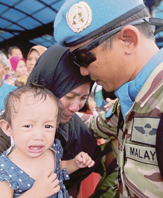 SARJAN Wan Muhd Najib menenangkan isterinya Salina Oden dan anaknya, Sharifah Najila, 1, di Pangkalan Udara TUDM, Subang, semalam. 