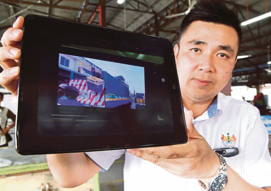  H'NG menunjukkan klip video  peniaga yang mengamuk selepas barang perniagaannya dirampas penguat kuasa MPSP kerana tidak mempunyai lesen tapak berniaga di Pasar Awam Taman Berjaya, Nibong Tebal, Pulau Pinang.
