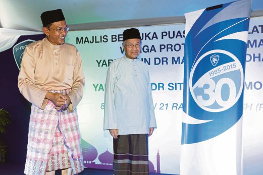 DR Mahathir melancarkan logo ulang tahun proton ke-30 disaksikan Abdul Harith.