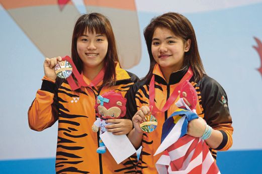WENDY (kiri) dan Dhabitah menunjukkan pingat emas dimenangi.