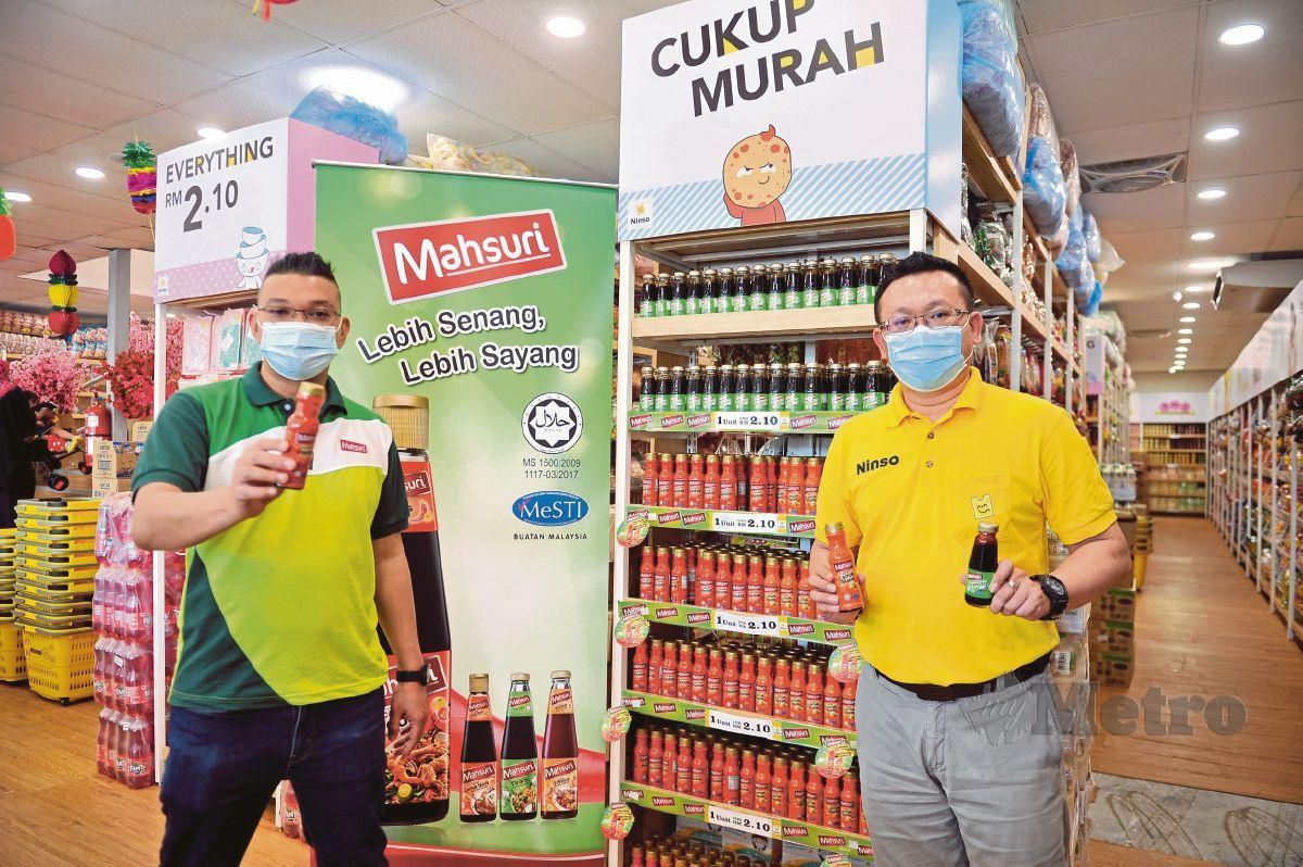 MOHD Jazri Ikmal (kiri) dan Tan menunjukkan produk keluaran Mahsuri Food.