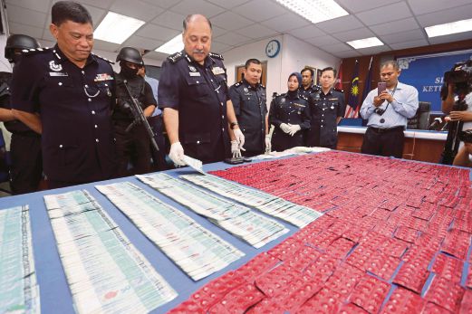  Mohd Mokhtar (dua dari kiri) menunjukkan dadah serta wang tunai yang dirampas daripada pengedar dadah di IPK Johor. 