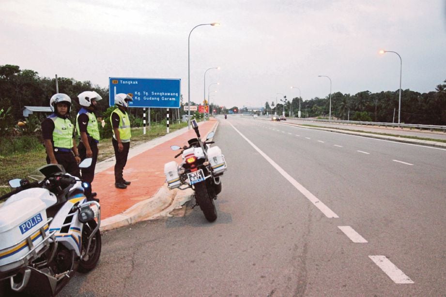   Anggota URB IPD Segamat memantau jalan di Kilometer 3 Jalan Segamat ke Muar yang dikenal pasti sebagai trek basikal lajak.