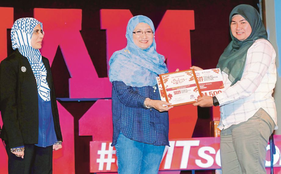 DR Nor Aieni  (tengah) menyampaikan sijil dan replika  kepada  Rozainah pada majlis Apresiasi Media UMT.