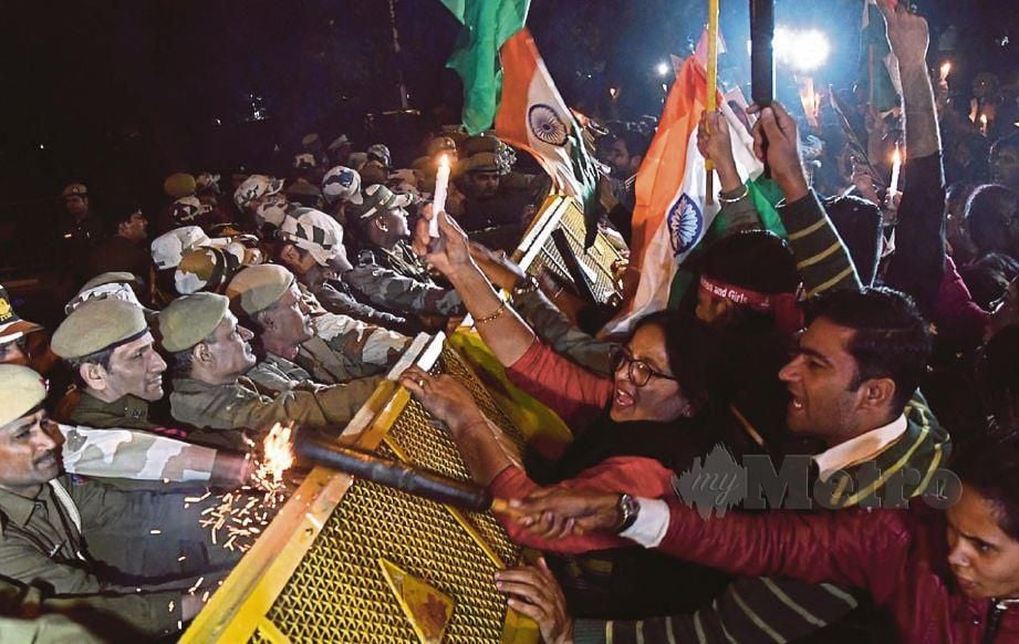POLIS New Delhi berusaha menghalang orang ramai yang menyertai protes membantah kejadian mangsa rogol dibakar, semalam. - Agensi