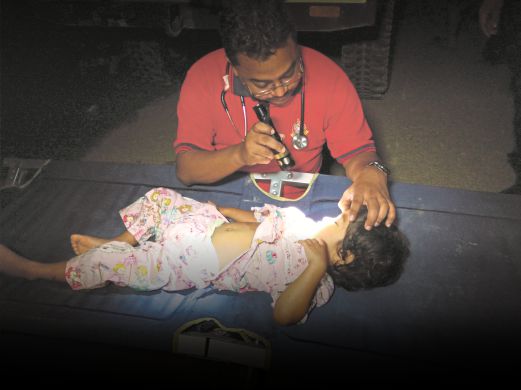 ANGGOTA perubatan memeriksa seorang kanak-kanak di Kuala Krai.
