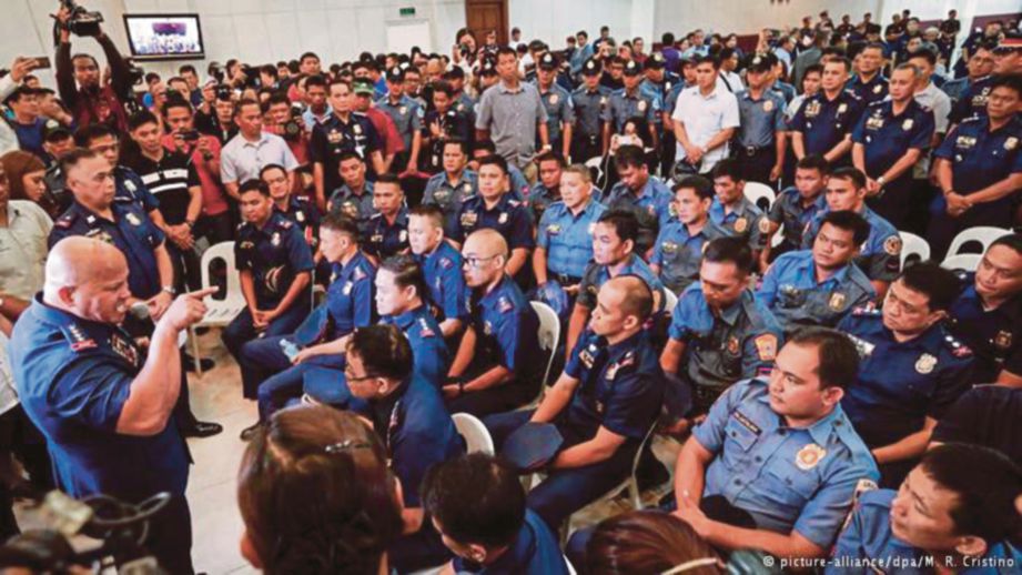 KETUA Polis Filipina, Ronald dela Rosa (kiri) memarahi anggota polis yang didakwa terbabit dalam perniagaan dadah di Quezon City, utara Manila, semalam.  