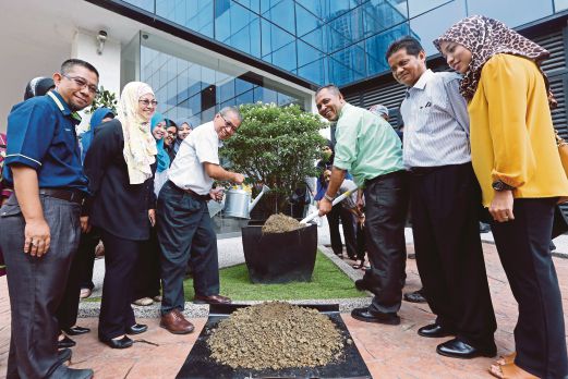 ABD Latif (kanan) dan Ahmad menanam pokok Susun Kelapa atau Sisik Kelah yang disumbang  FRIM di halaman Balai Berita Bangsar.