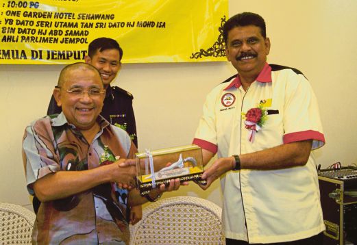 ISA (kiri)  menerima cenderahati daripada   Mohd Rofik  selepas merasmikan Mesyuarat Agong Persatuan Pengusaha Bas Sekolah Negeri Sembilan.
