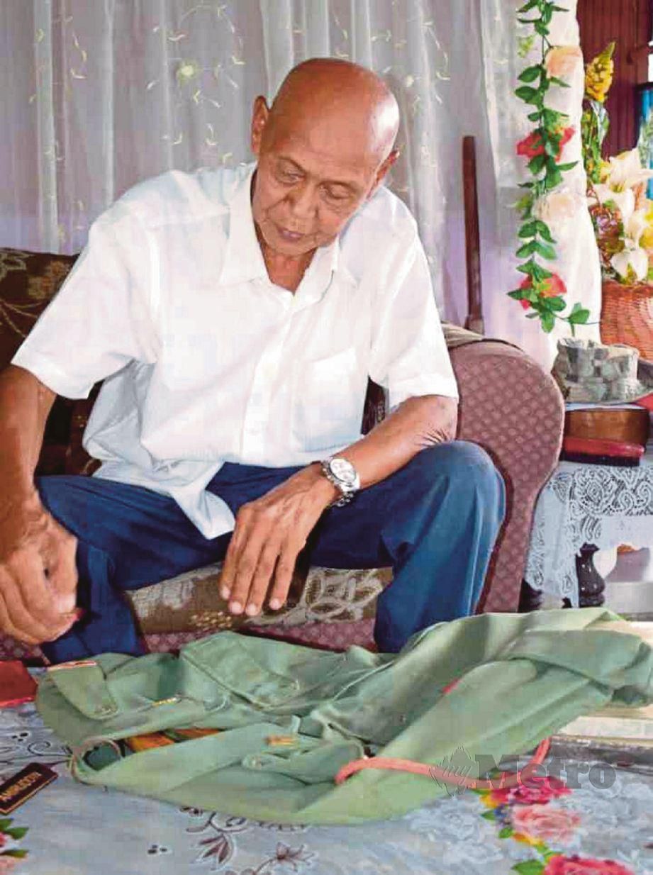  Amirudin  menunjukkan pakaian tentera yang masih disimpan   dan Pingat Jasa Malaysia (PJM) yang diterimanya selepas 22 tahun berkhidmat. 