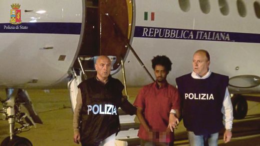 MERED (tengah) diiringi polis menaiki pesawat ke Itali.