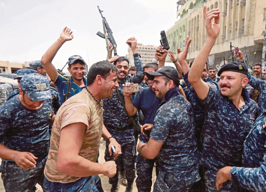 POLIS persekutuan Iraq menari di Bandar Lama Mosul selepas berjaya menawan kawasan itu daripada militan Daish semalam. - Reuters