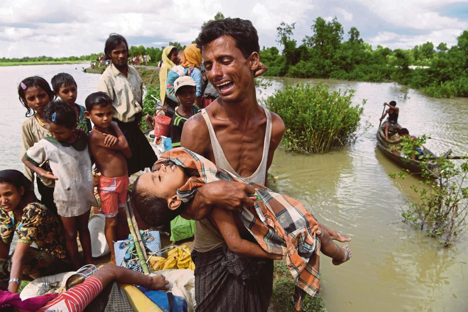 SEORANG lelaki mendukung anaknya yang maut dalam kejadian bit terbalik di Sungai Naf, Bangladesh.