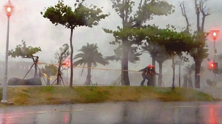 DUA orang dilihat meredah angin kencang dibawa Taufan Nepartak di Taitung. 
