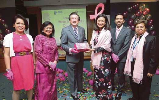 Stanley (tengah) menyampaikan cenderahati penghargaan kepada Dr Azlina pada majlis  pelancaran kempen Wear It Pink 2015.