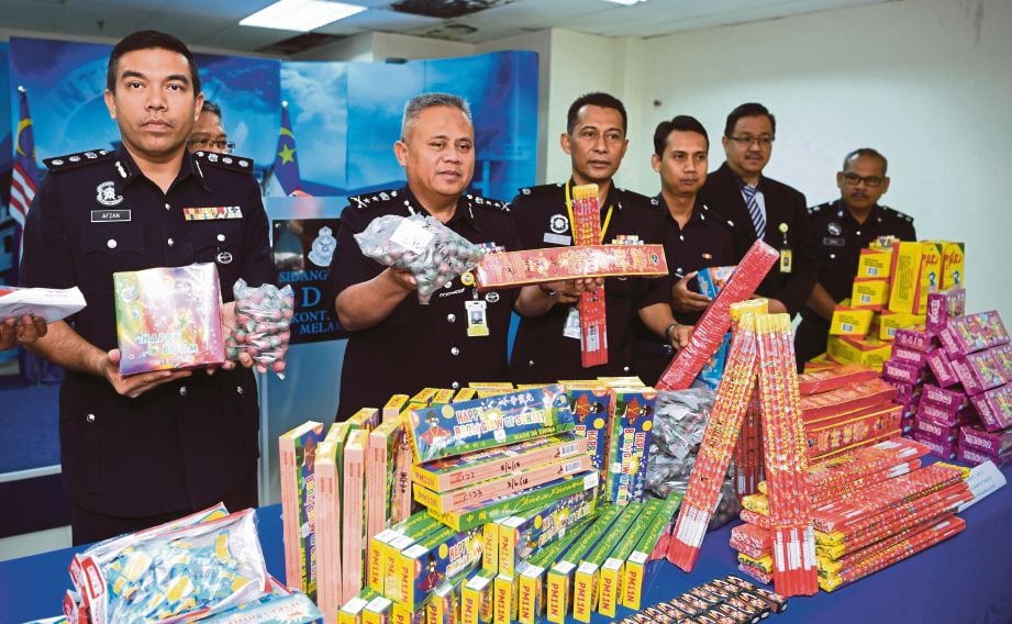 Abdul Jalil  (kiri) bersama pegawainya menunjukkan mercun dan bunga api yang dirampas dengan nilai anggaran RM10,000.