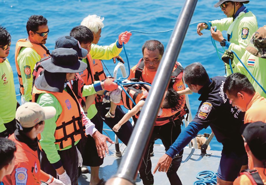 ANGGOTA penyelamat membawa naik mayat seorang kanak-kanak lelaki yang menjadi mangsa bot karam di Phuket ke atas bot penyelamat, kelmarin. - Foto EPA