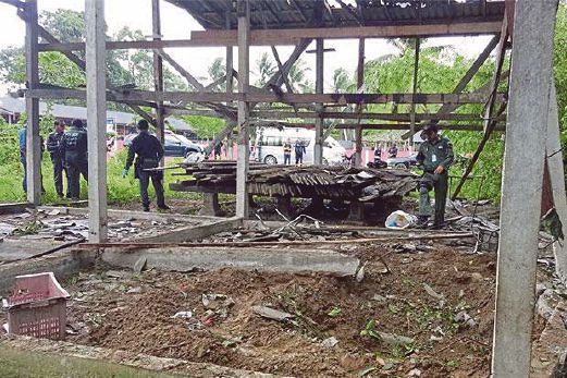 ANGGOTA polis menyiasat lokasi serangan bom di daerah Yaring di Pattani, semalam.