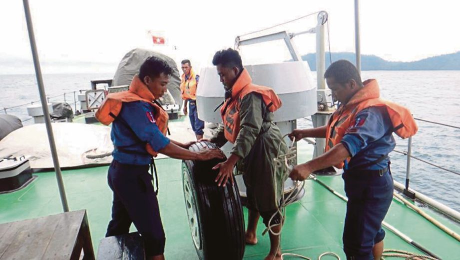 ANGGOTA tentera laut Myanmar memeriksa roda kapal terbang yang dipercayai milik pesawat yang terhempas di Laut Andaman, semalam.  -  EPA