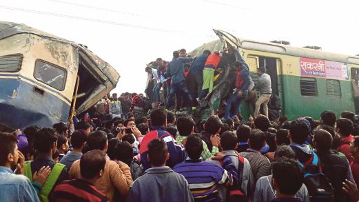 ORANG ramai berkerumun untuk melihat sendiri kesan kemalangan kereta api di utara India, semalam.
