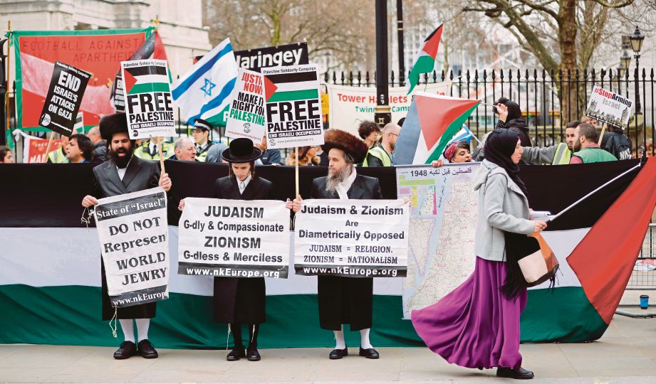 LELAKI Yahudi Ultra-Ortodoks menyertai tunjuk perasaan membantah kekejaman Israel di Gaza dalam satu perhimpunan di Downing Street di London kelmarin. - AFP 
