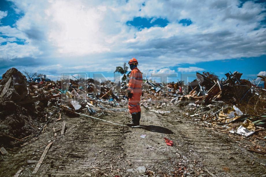 ANGGOTA penyelamat sedih melihat runtuhan di Petobo di  Sulawesi Tengah.