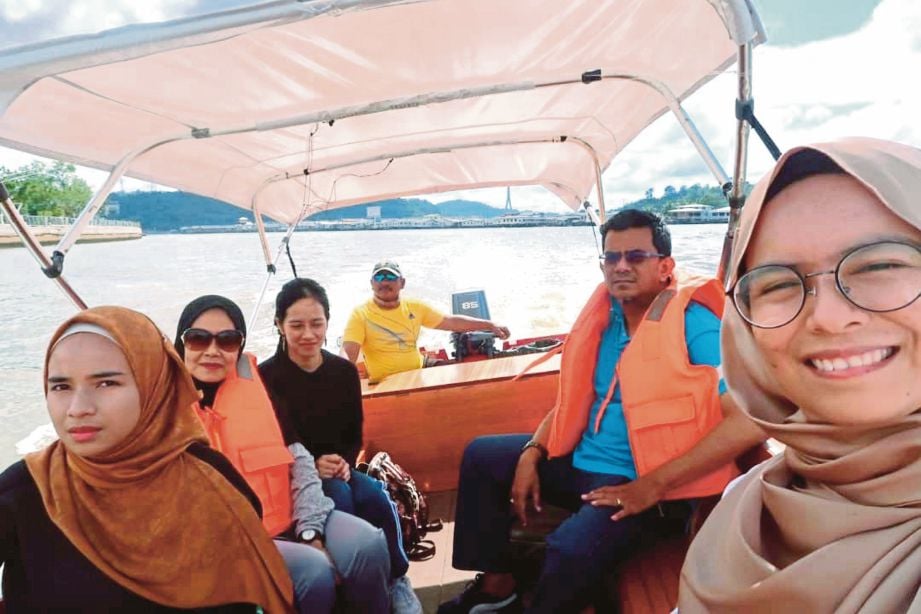 PENULIS (kanan) dan keluarga ketika melewati Sungai Brunei.