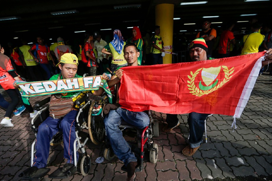 ABDUL Malik bersama rakan penyokong Kedah tak lepaskan peluang berada di Stadium Shah Alam. -Foto NSTP