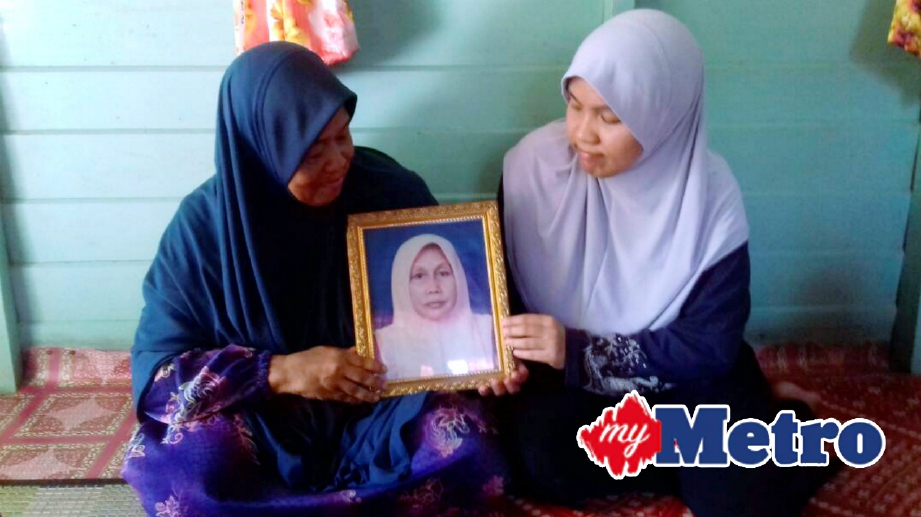 WAN Rafiah Musa, 63, (kiri) menunjukkan gambar arwah kakaknya, Wan Halimah Musa, 66 yang meninggal dunia di depan Kaabah 16 September lalu ketika mengerjakan haji. FOTO Syaherah Mustafa
